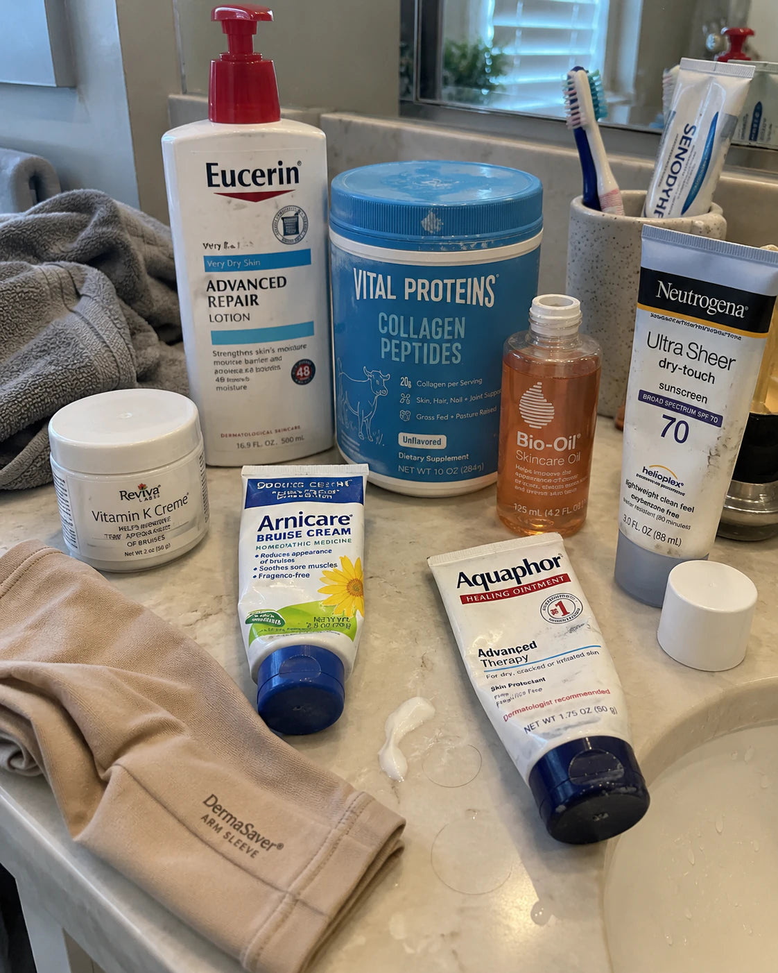 Lotions, bruise creams, collagen powder and a protective sleeve on a bathroom counter